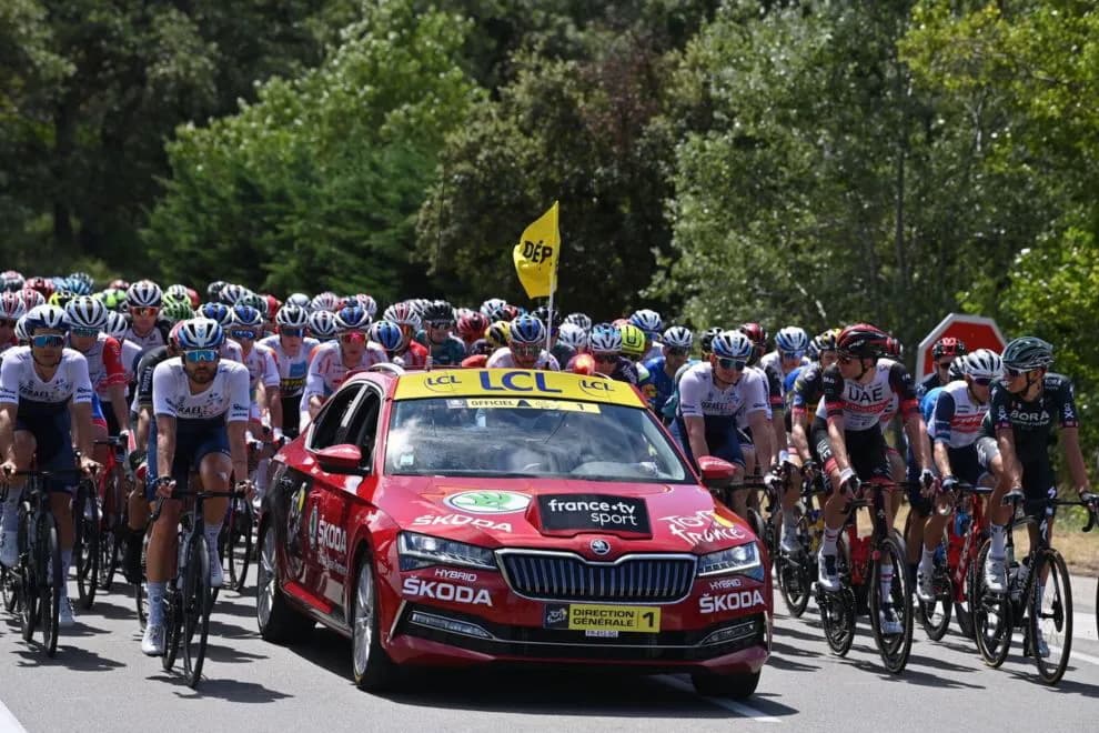 Official red Tour de France race director car leading the peloton