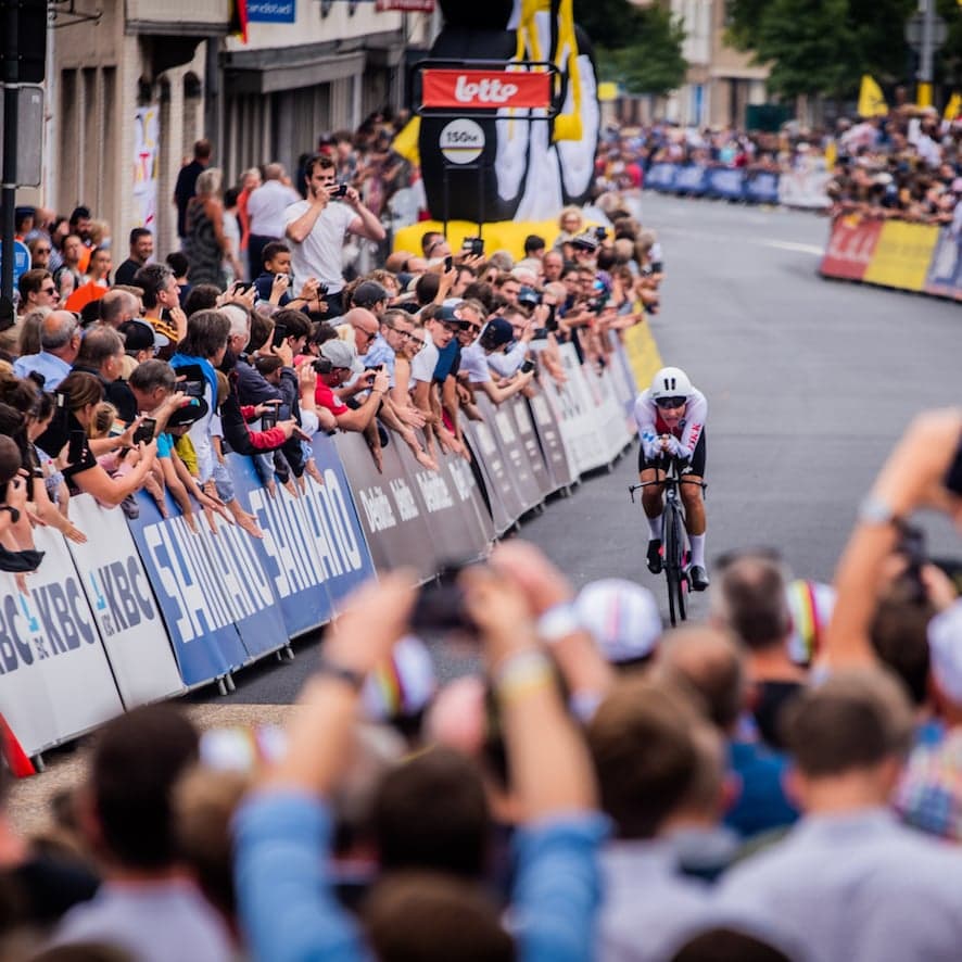 Cyclist in time trial, crowd lined street