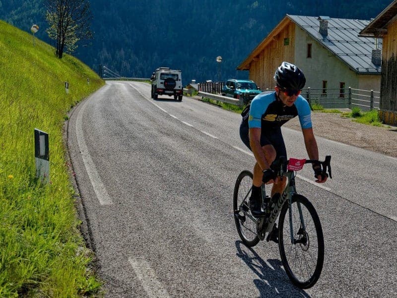 Cyclist in Mummu Cycling kit on winding road