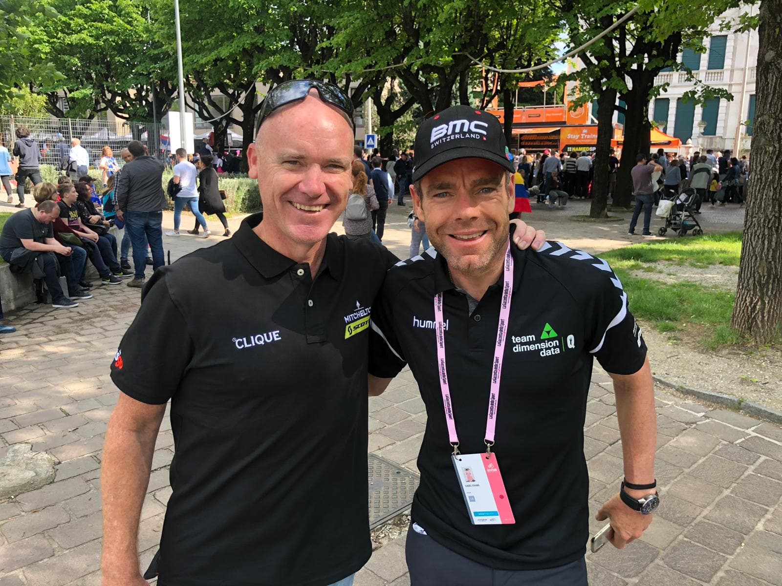 Two men smiling: one in Mitchellton-Scott polo, the other in Team Dimension Data polo.