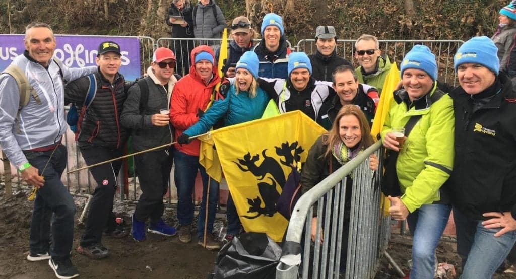 Group of cycling fans with Mummu Cycling hats and a flag.