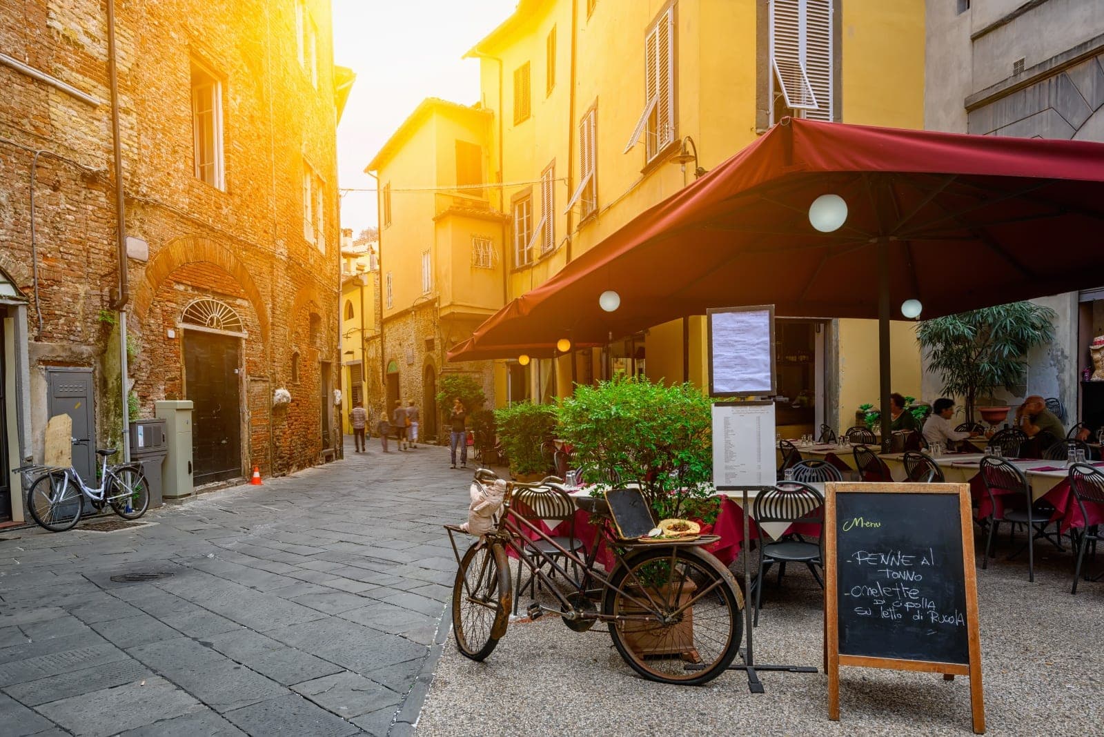 Lucca street scene with bicycle and restaurant