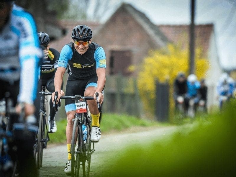Cyclist in Mummu Cycling kit on a cobbled road