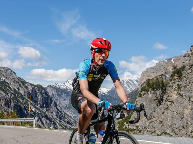 Cyclist in Mummu Cycling kit climbing in the mountains.